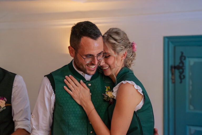 Hochzeitsfotograf Allgäu und Kempten. Die Braut schmiegt sich im Standesamt an die Schulter ihres Mannes. Beide lächeln vertraut.